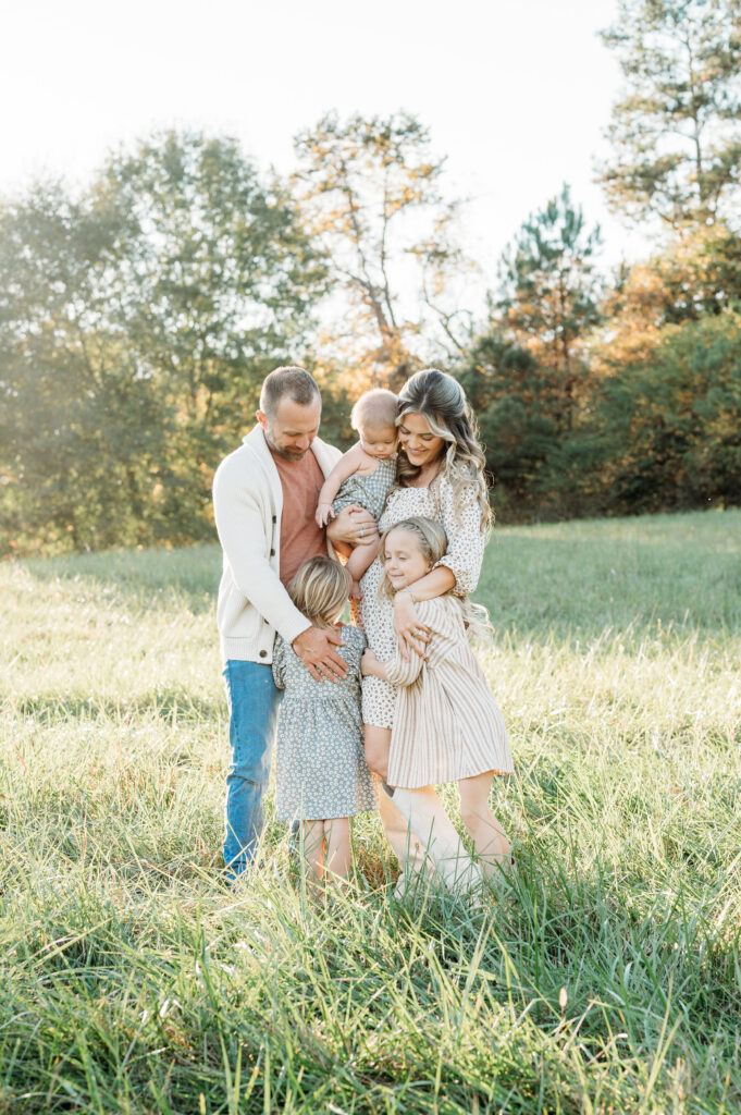 Family Session at Birmingham Park in Milton, GA is at sunset, and all family members are laughing and enjoying each other.