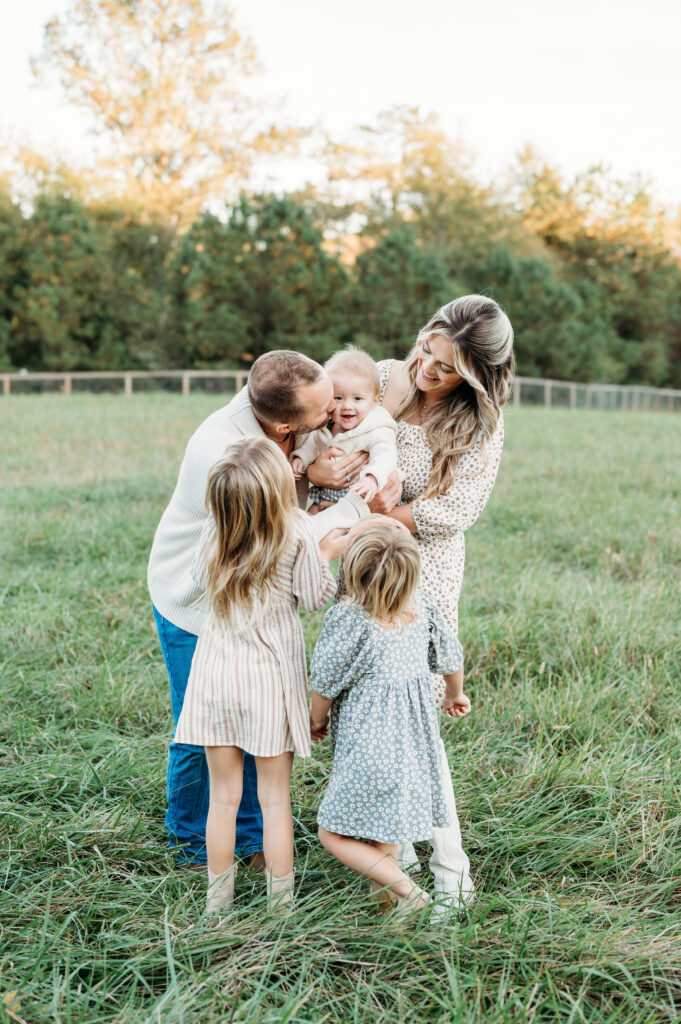 The family session in Birmingham Park, Atlanta, is at sunset, and all family members are laughing and enjoying each other.