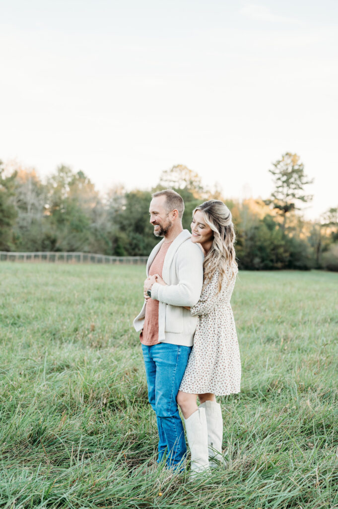 Mum is huging dad while they are watching their kids during thier family session in Birmingham Park in Atlanta.