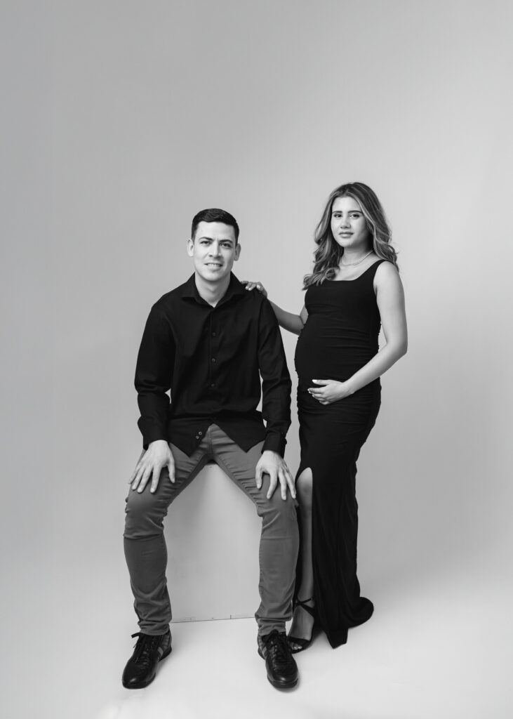 Black and white studio picture of a pregnant woman and her husband during their maternity photo session in Atlanta