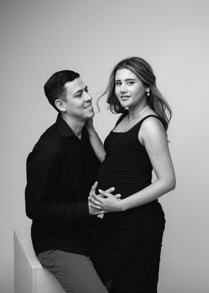 Black and white studio picture of a pregnant woman and her husband during their maternity photo session in Atlanta